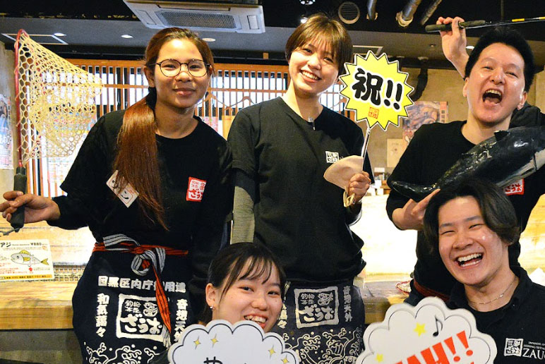 笑顔で記念写真を撮るスタッフたちの集合写真